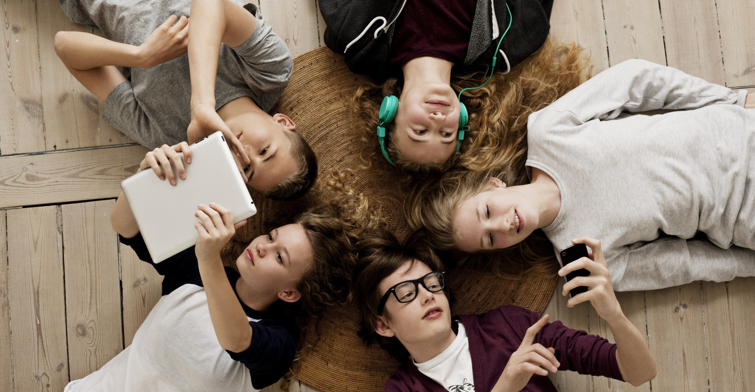 Teenagers lying on floor with Ipad and mobile